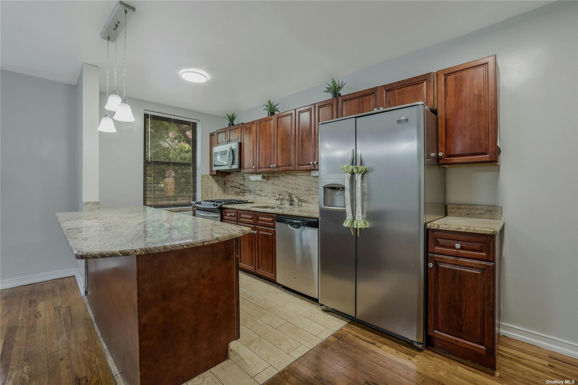 a kitchen with stainless steel appliances granite countertop a refrigerator a sink and a stove