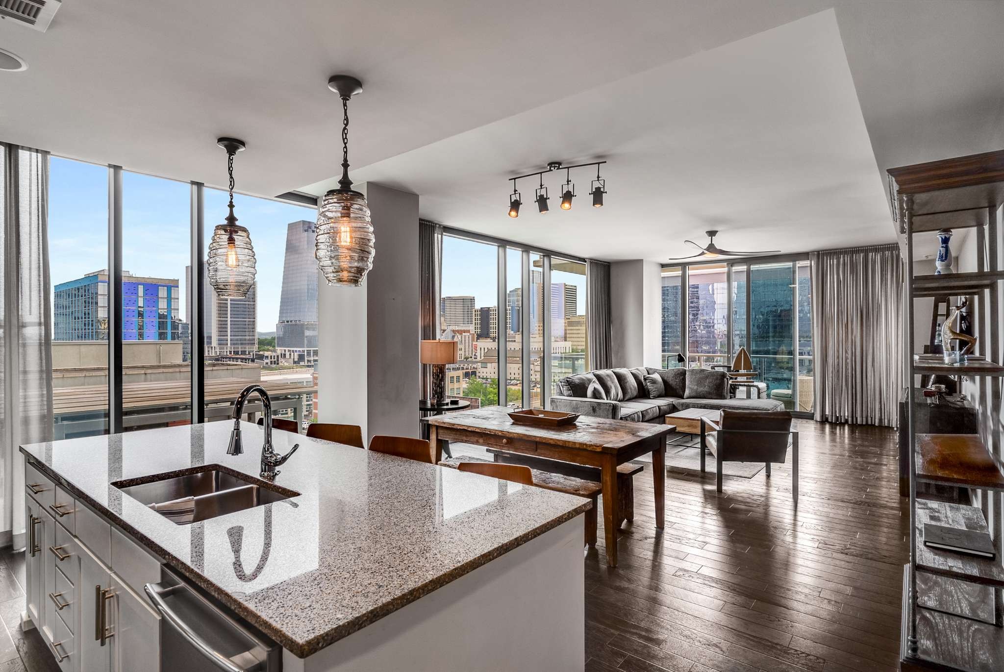 a kitchen with stainless steel appliances granite countertop a stove and a view of living room