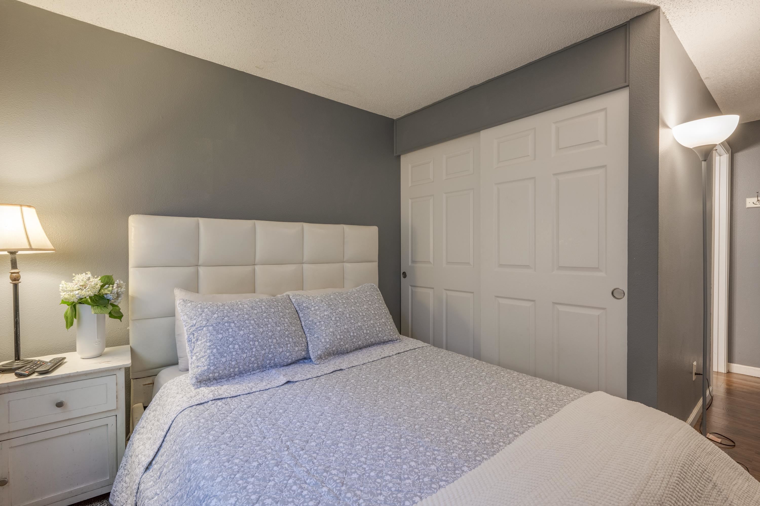 a bedroom with a bed and a potted plant