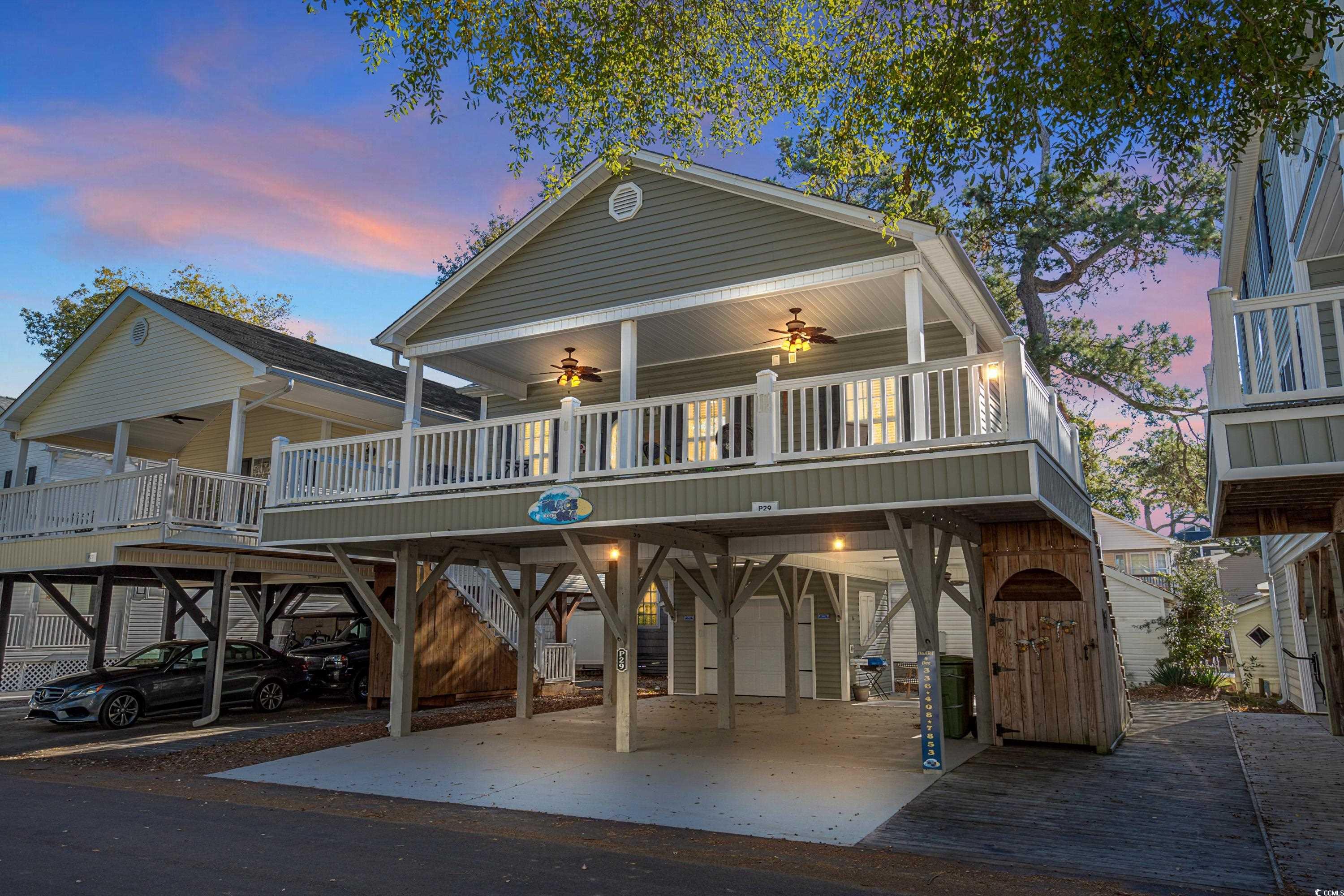 Back house at dusk featuring a carport and ceiling