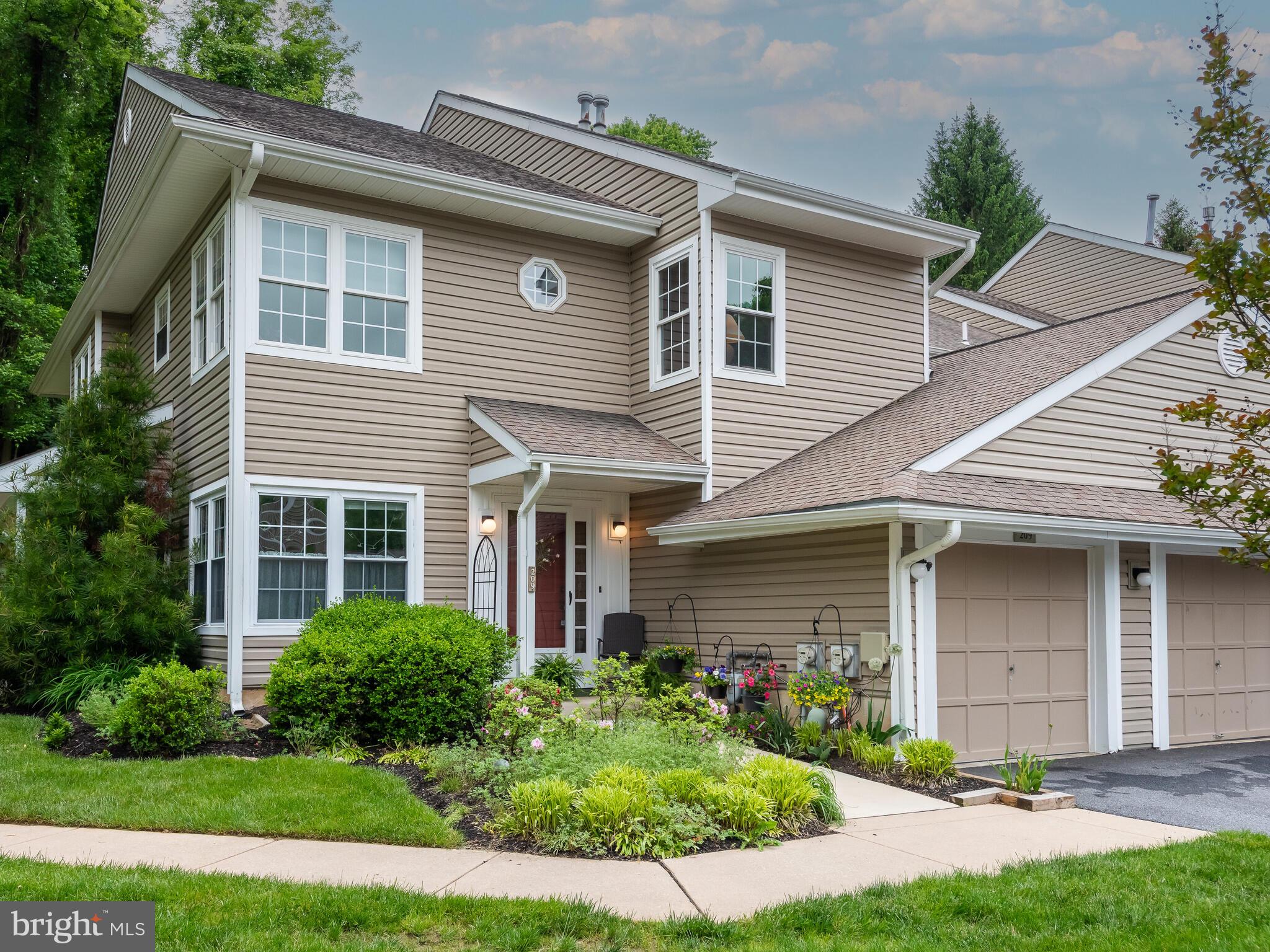 a front view of a house with a yard and potted plants