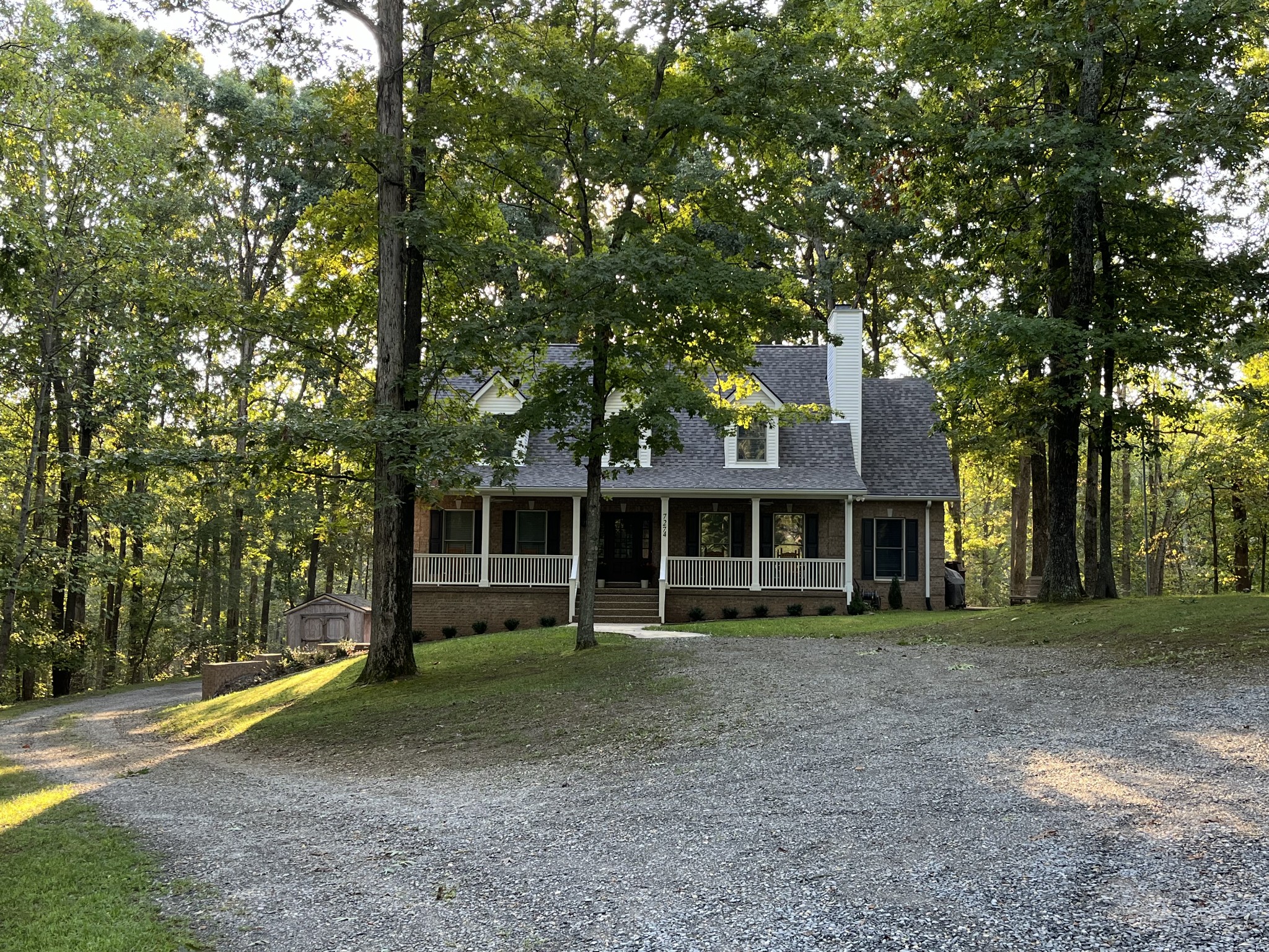 a front view of a house with a yard and trees