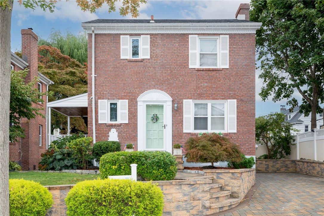 front view of a brick house with a yard