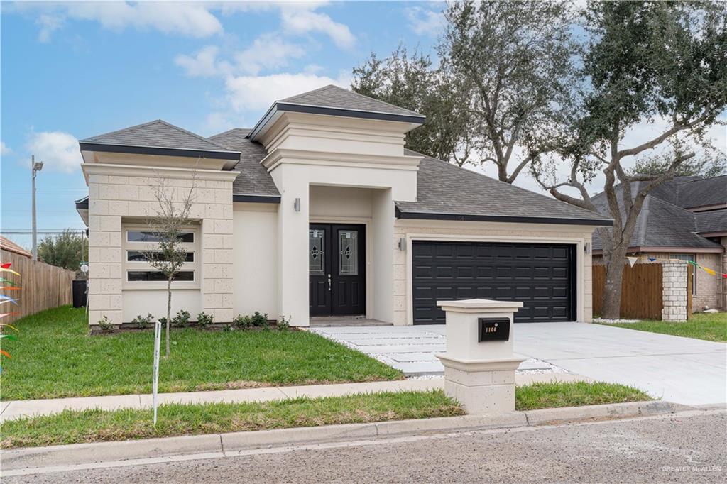 a front view of a house with a yard and garage