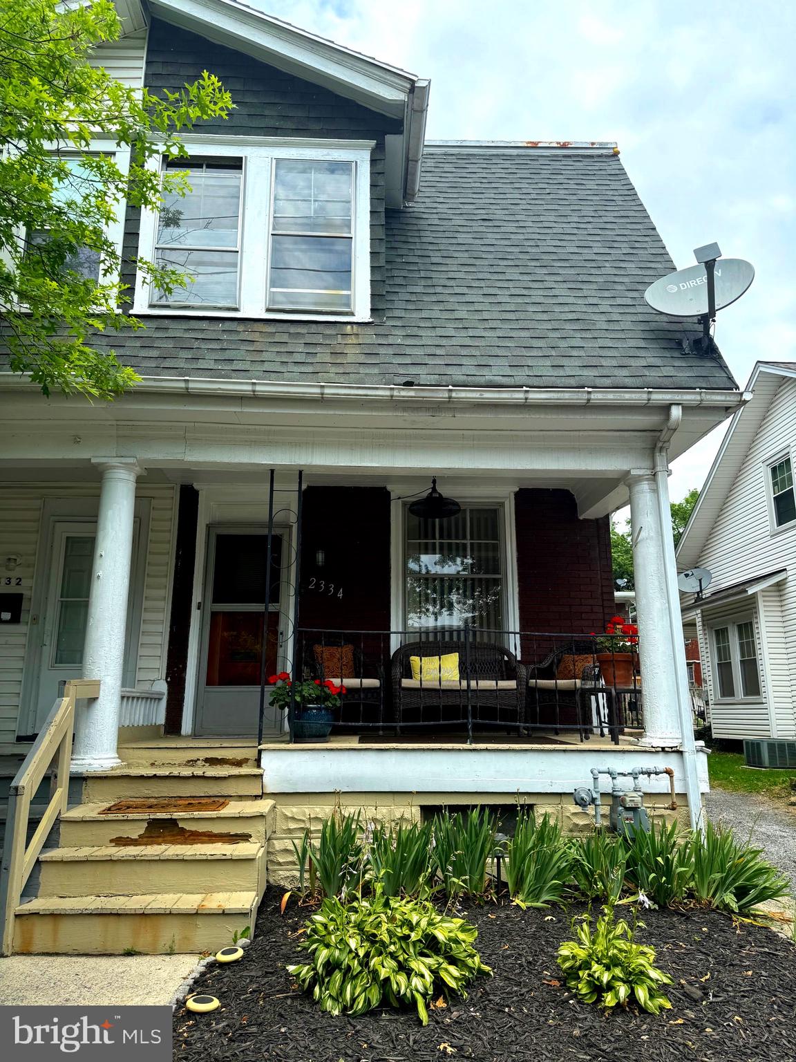 a view of a house with potted plants and a table and chairs