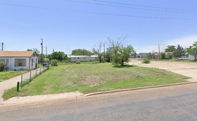 a view of a house with a yard and a street