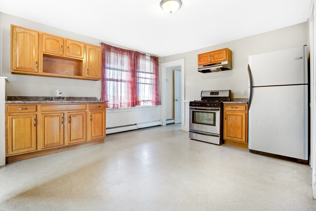 a kitchen with stainless steel appliances granite countertop a stove a sink and a refrigerator