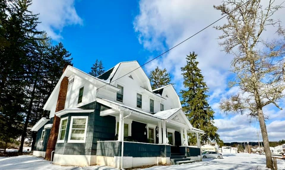 View of snow covered exterior featuring covered porch