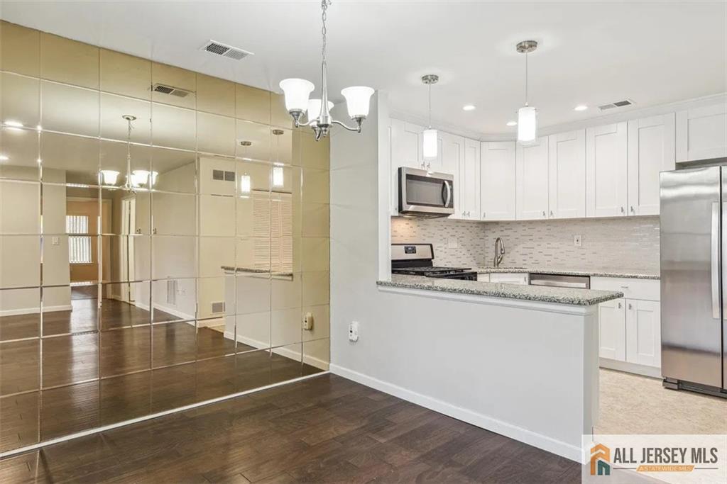 a large kitchen with kitchen island a sink stainless steel appliances and cabinets