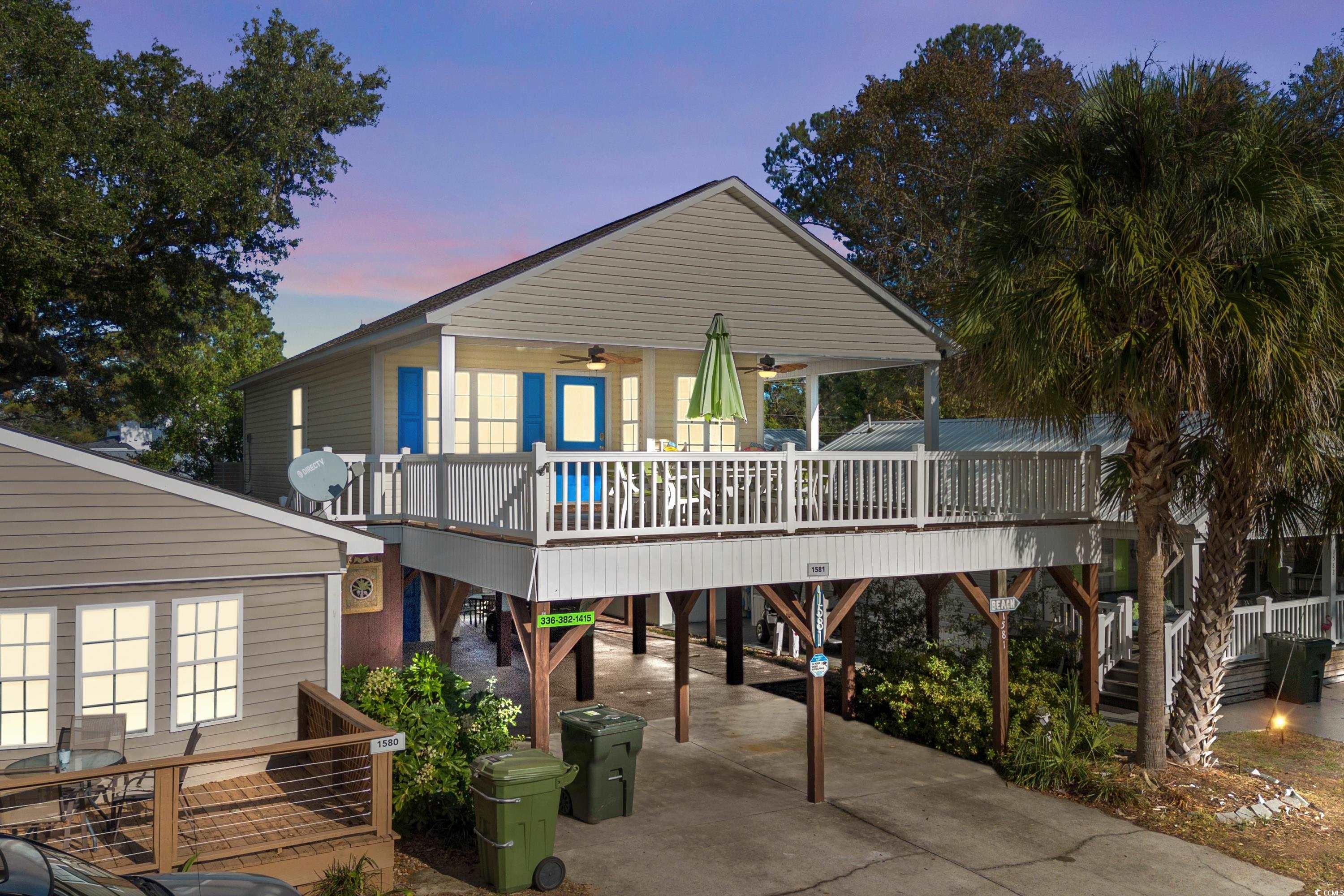 Back house at dusk with ceiling fan, a deck, and a