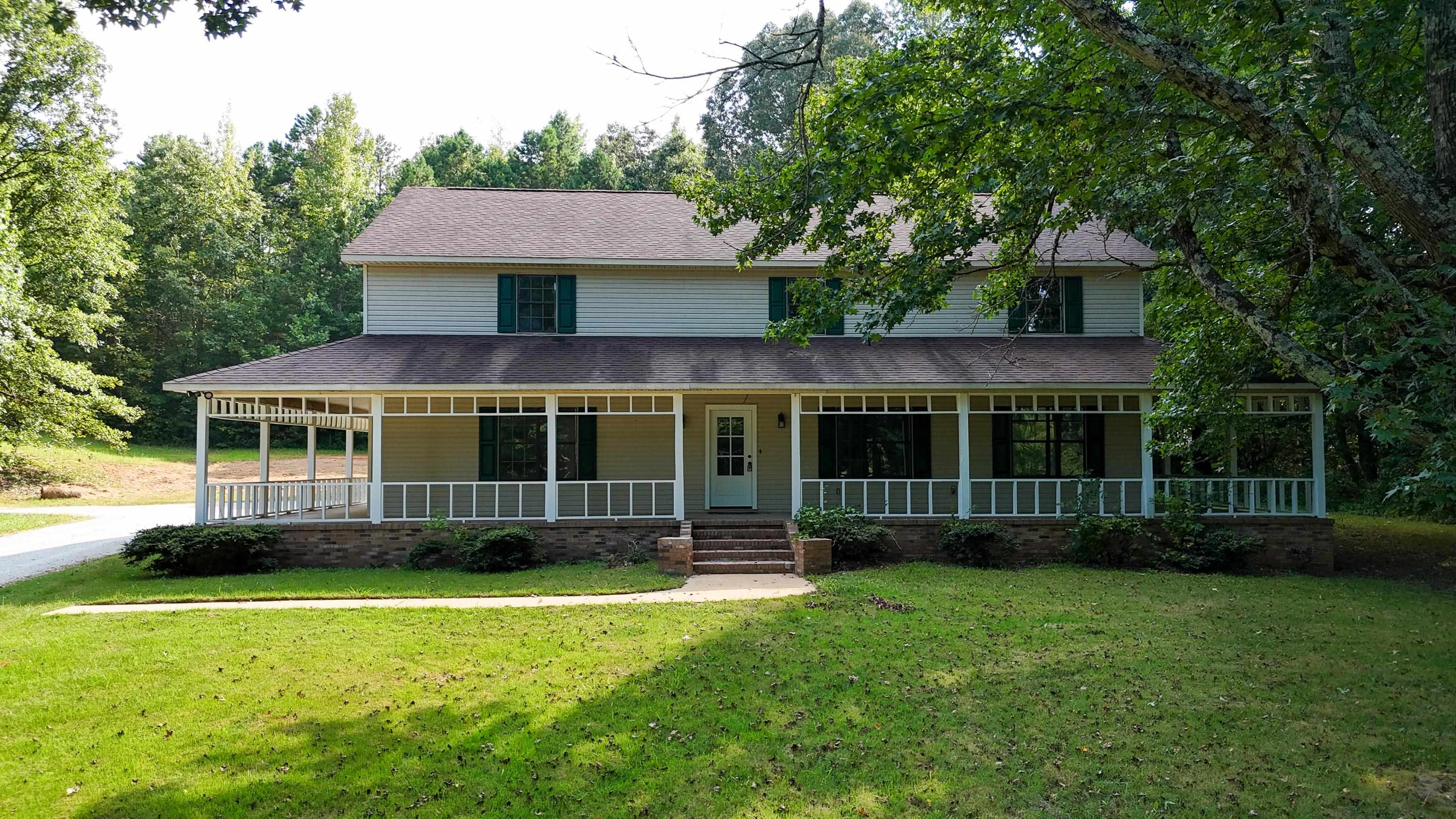 Farmhouse inspired home with a porch and a front yard