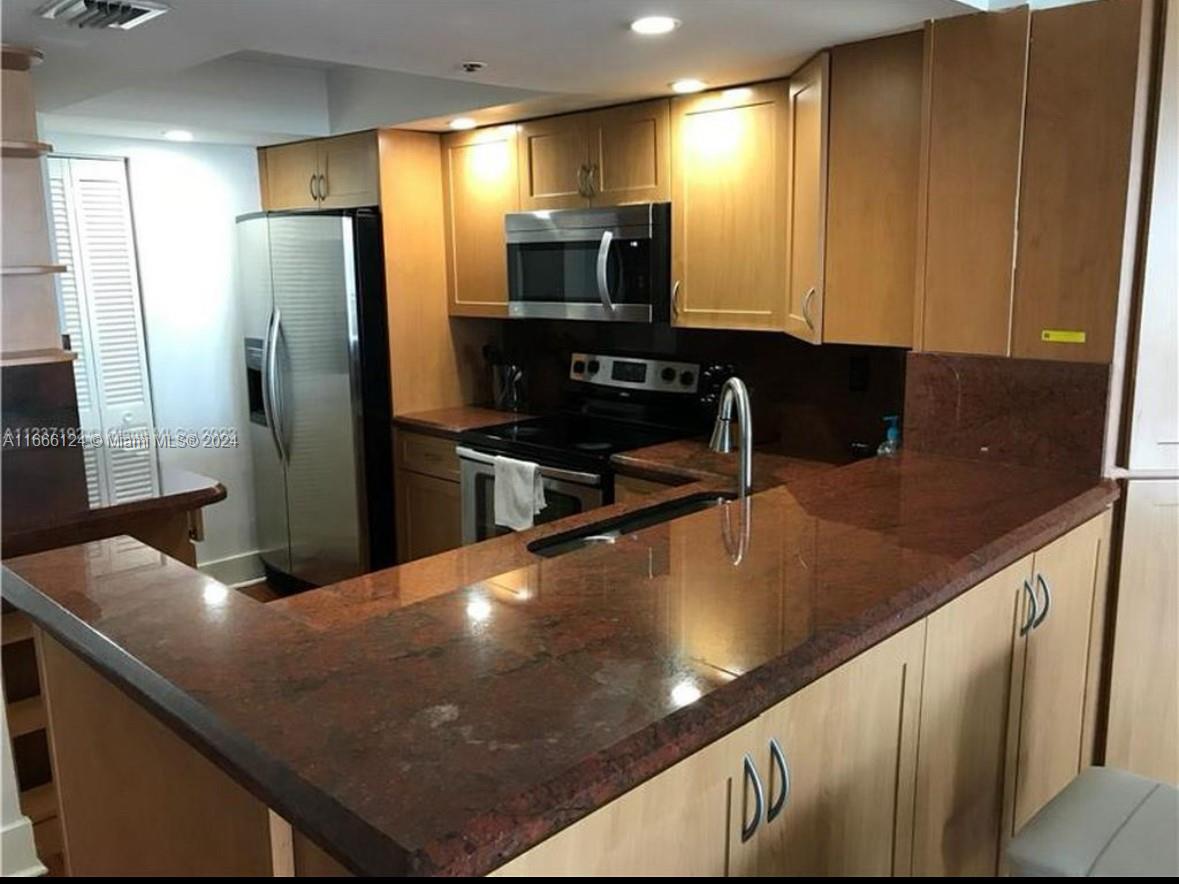 a kitchen with kitchen island a sink appliances and cabinets