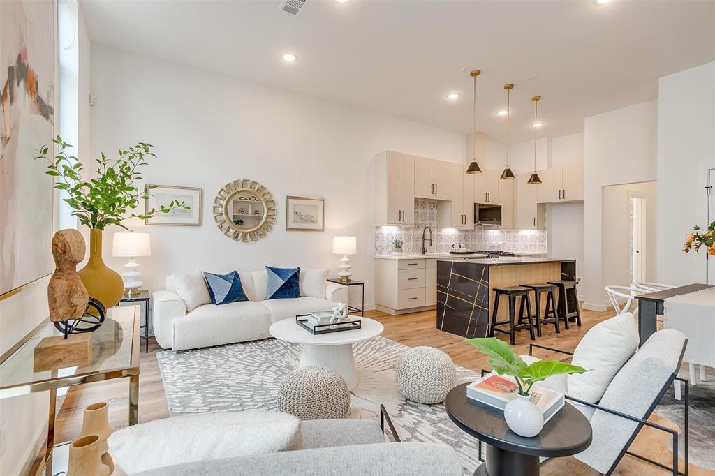 a living room with fireplace furniture and a kitchen view