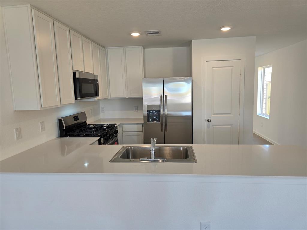 a kitchen with a refrigerator a sink and cabinets