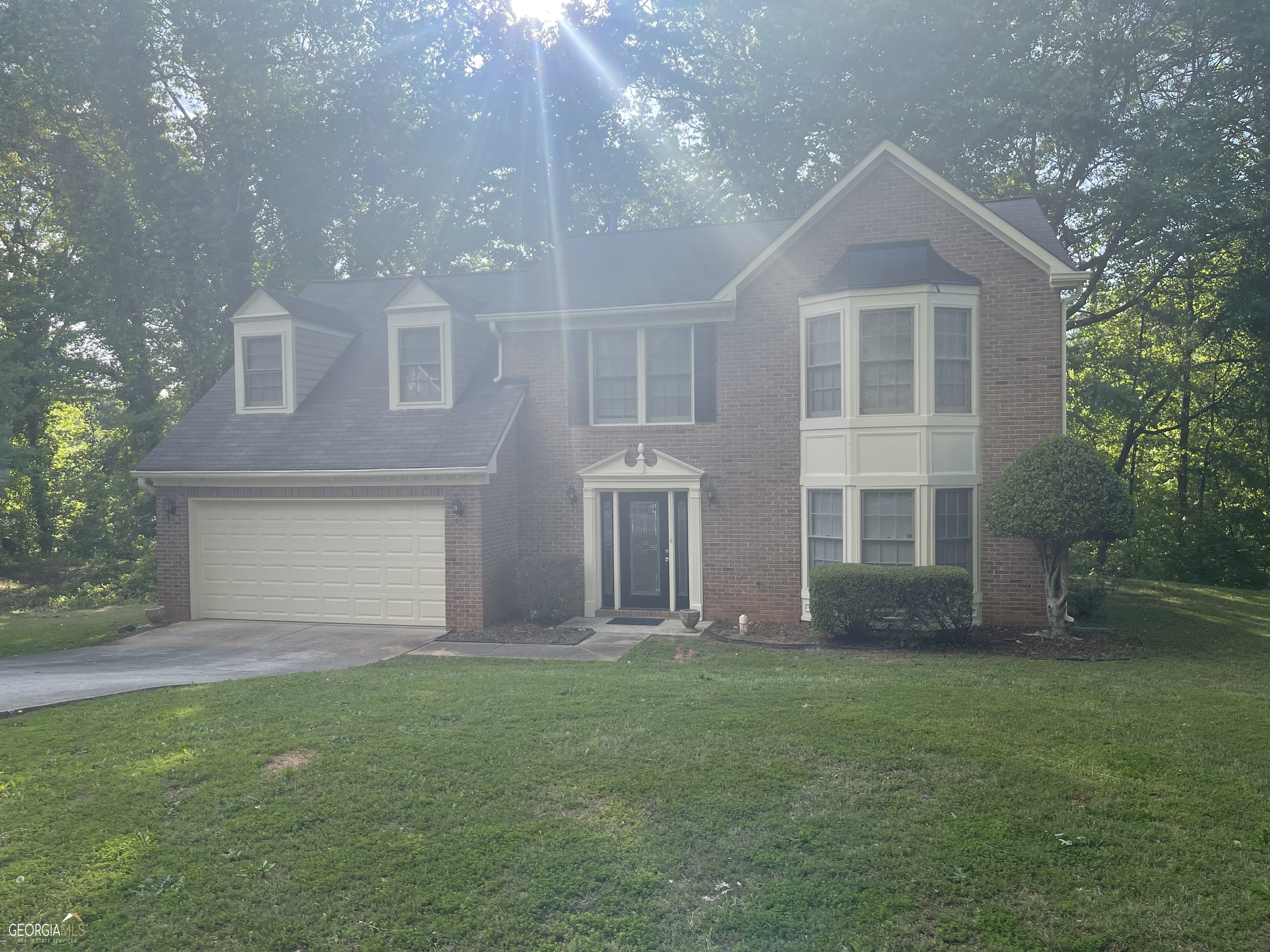 a front view of a house with a garden and yard