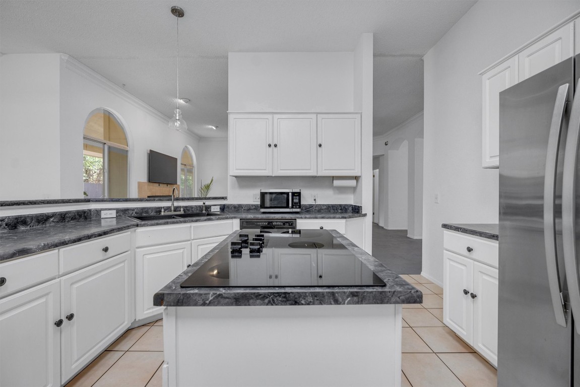 a kitchen with white cabinets and appliances