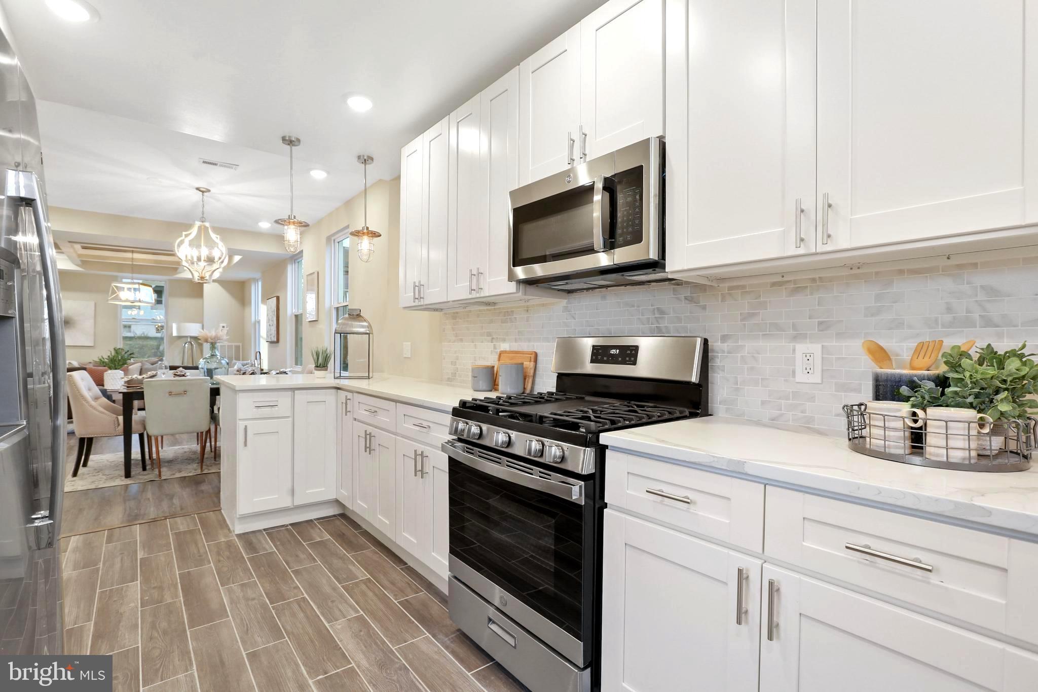 Backsplash, quartz counters, gorgeous lighting