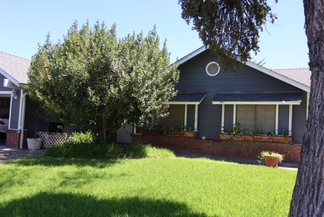 a view of a house with backyard and sitting area