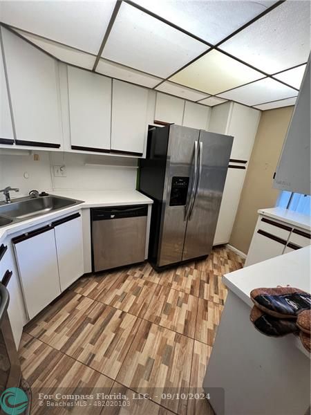 a kitchen with sink and refrigerator