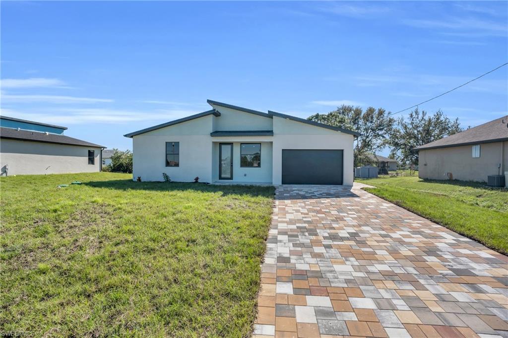 View of front facade featuring a front lawn and a garage