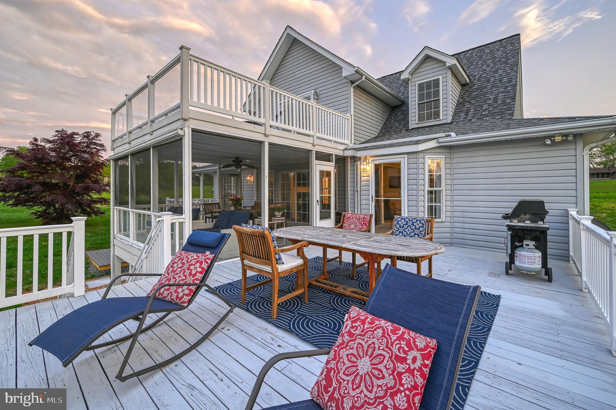 a view of a house with wooden deck and furniture