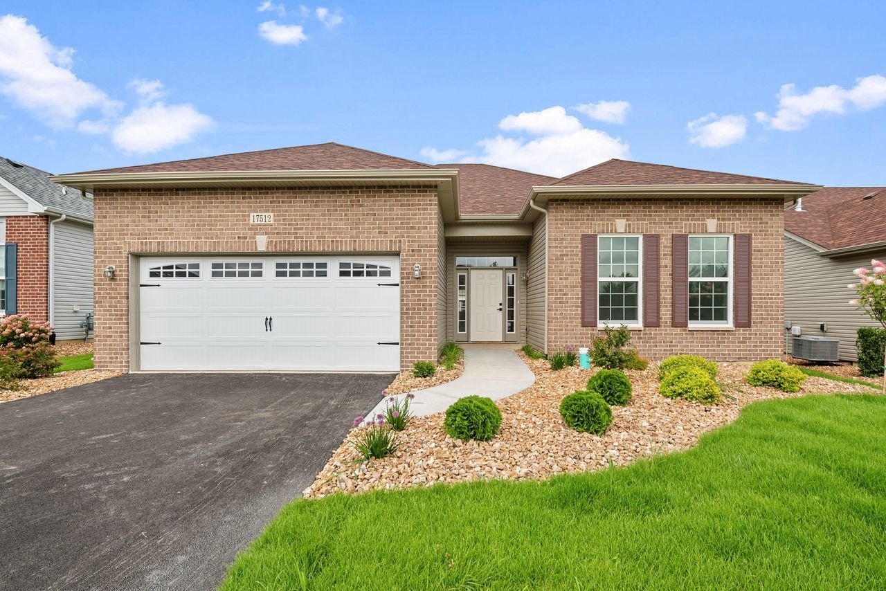 a front view of a house with a yard and garage