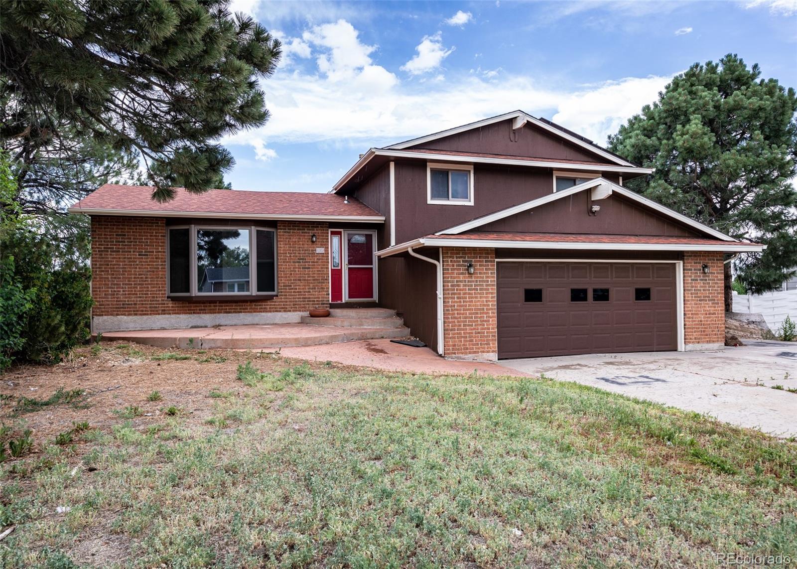 a front view of a house with yard and garage