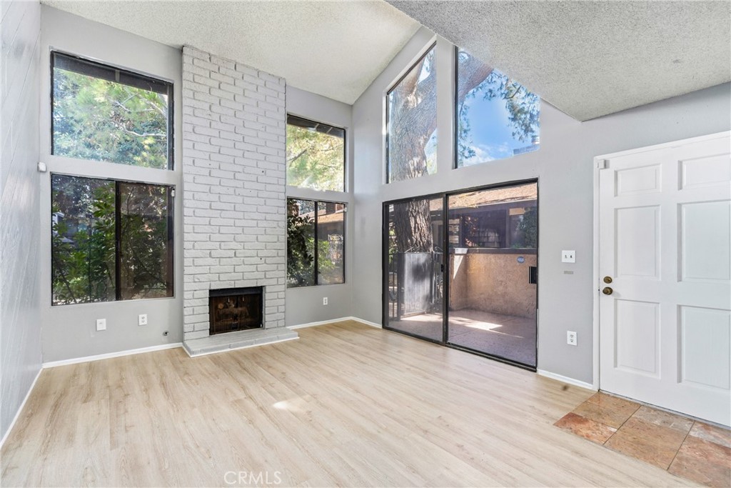 a view of an empty room with a fireplace and a window