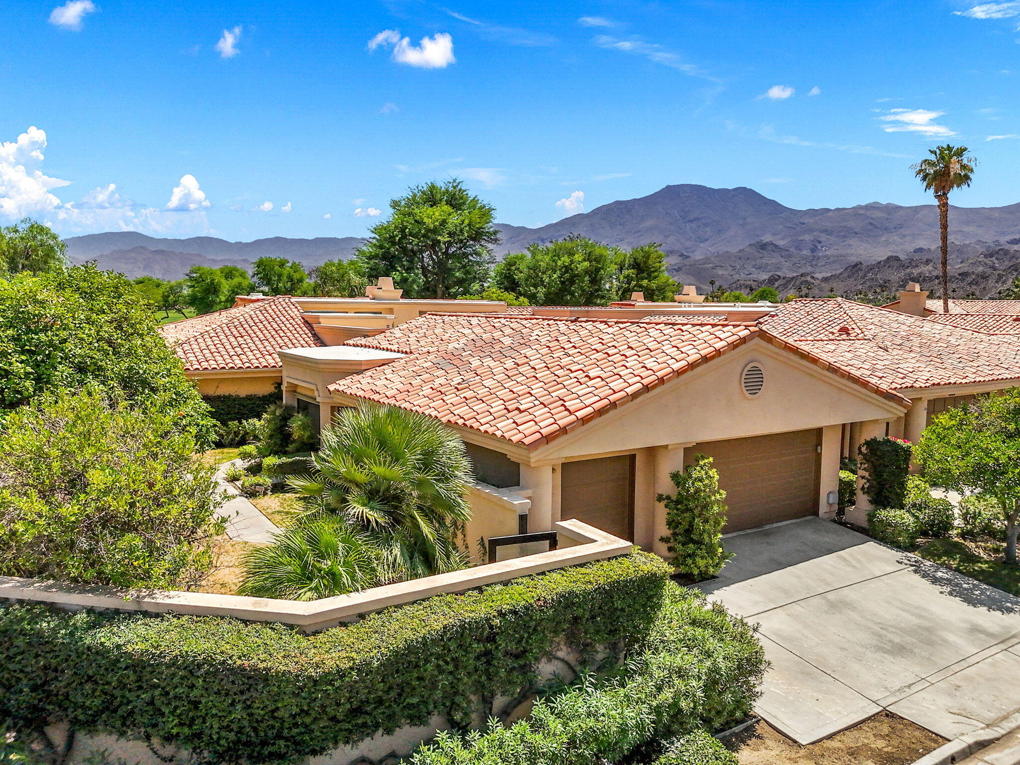 a front view of a house with a yard and mountain