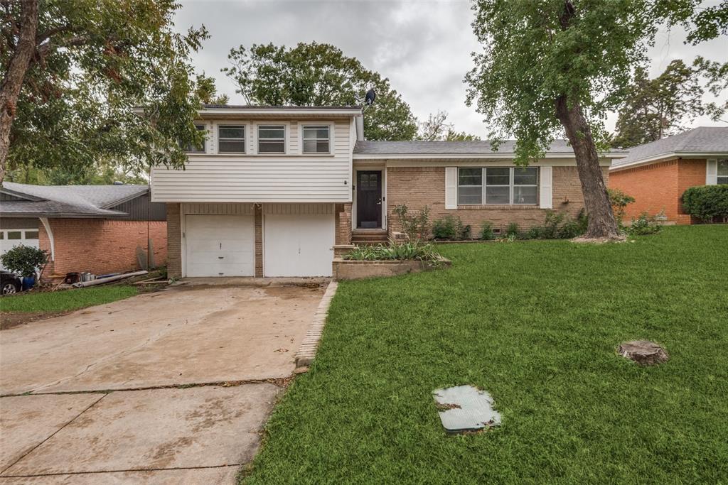 a front view of a house with a garden and yard