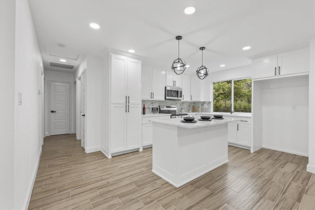 a kitchen with stainless steel appliances granite countertop a sink cabinets and wooden floor