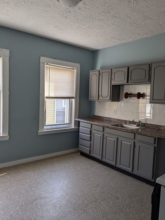 a kitchen with granite countertop a sink cabinets and window