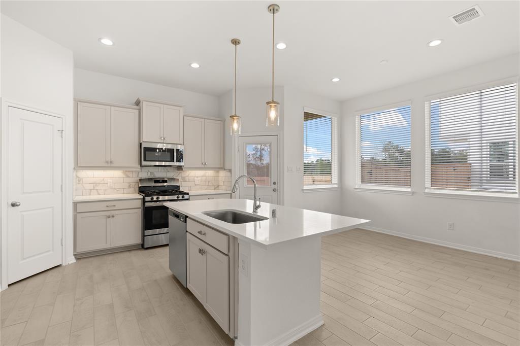 a kitchen with stainless steel appliances granite countertop a sink stove and refrigerator