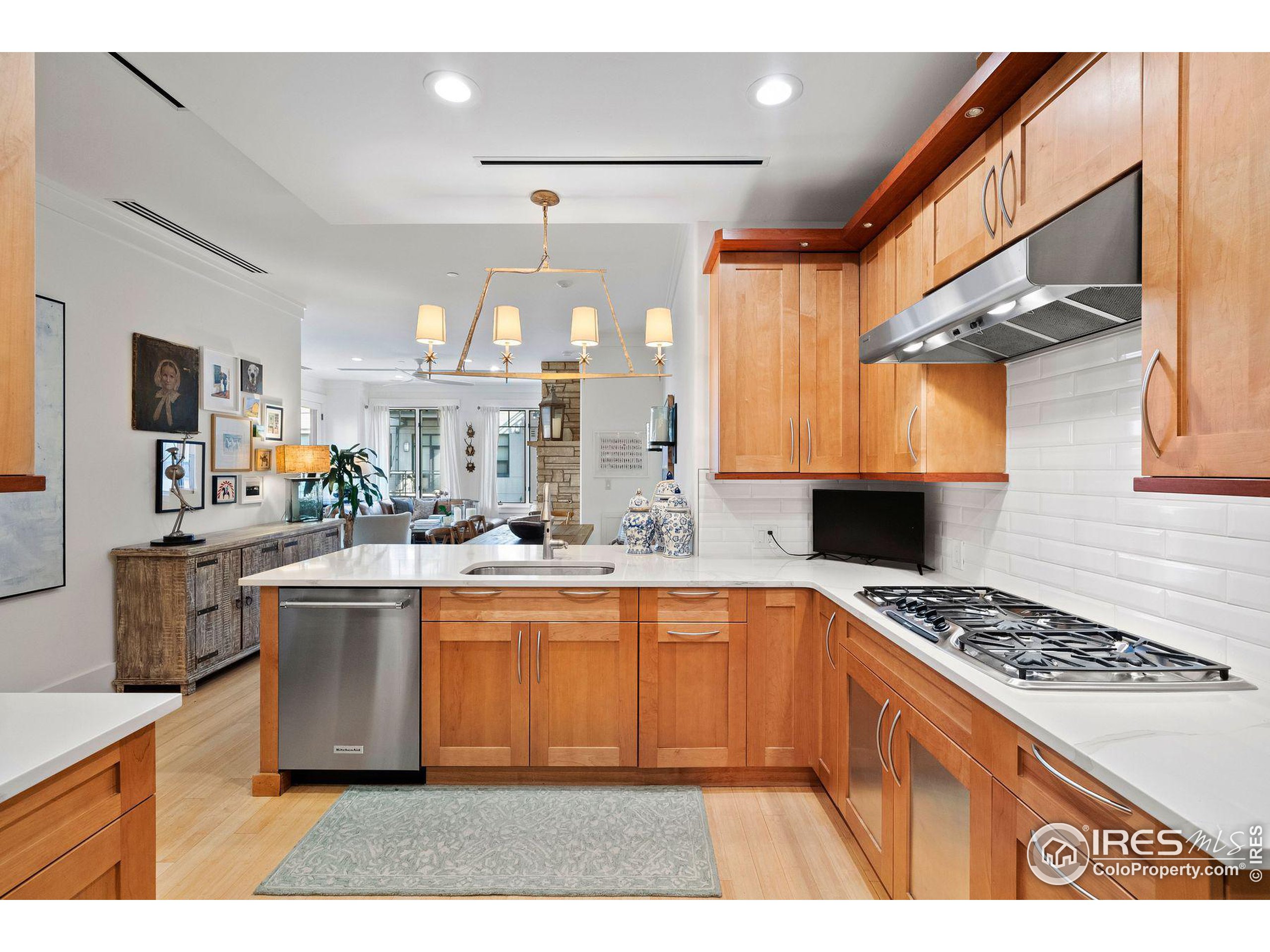 a kitchen with stainless steel appliances a sink a stove a refrigerator cabinets and a dining table