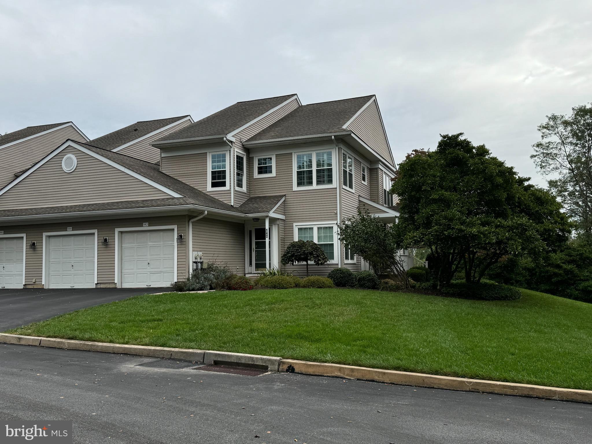 a front view of a house with a yard and trees