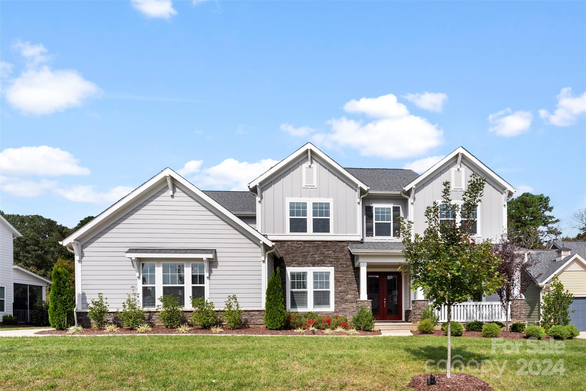 a front view of a house with a yard and trees