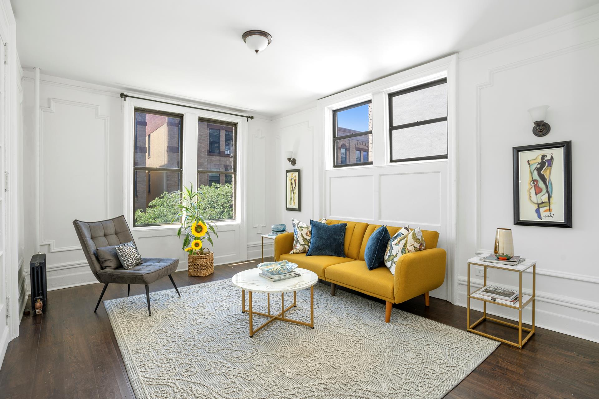 a living room with furniture and a potted plant next to a window