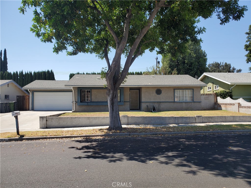 a front view of house with yard and trees in the background