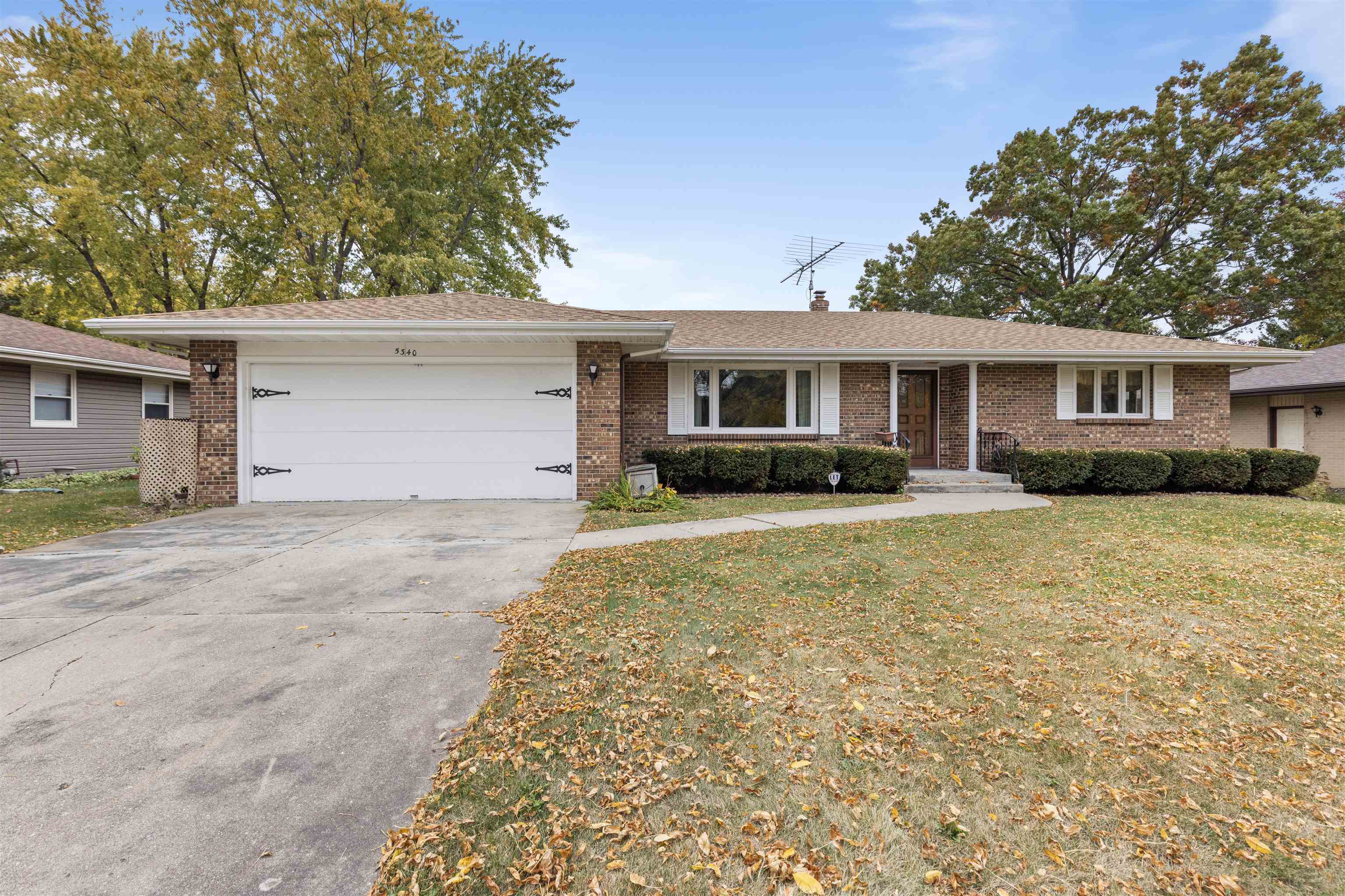 a front view of house with yard space and trees around