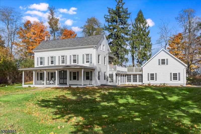 a front view of a house with a garden and trees