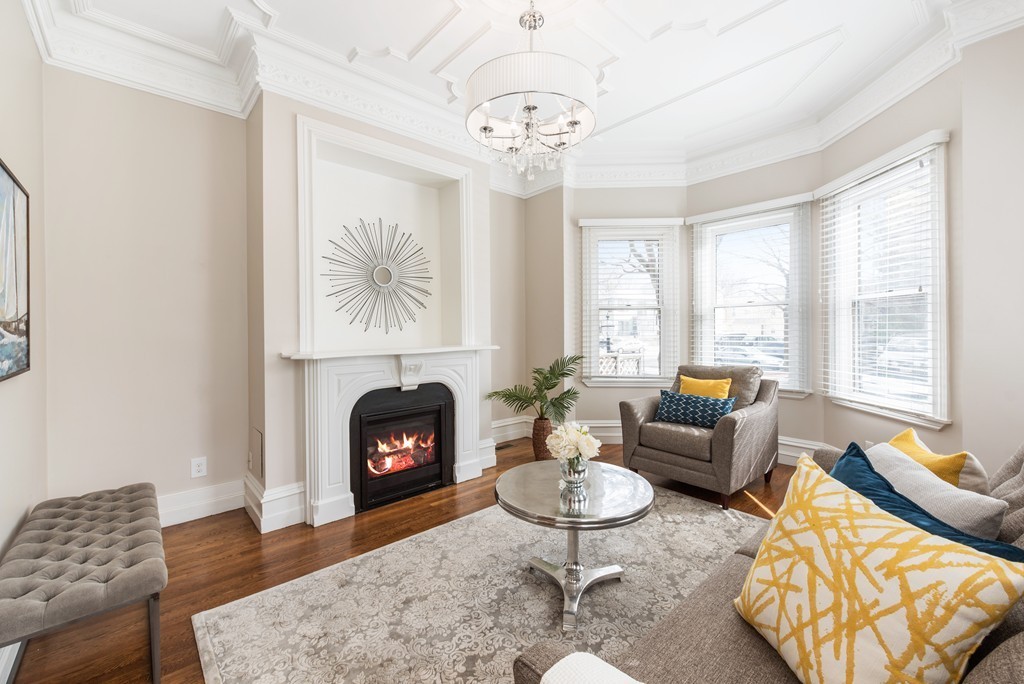 a living room with furniture a fireplace and a large window