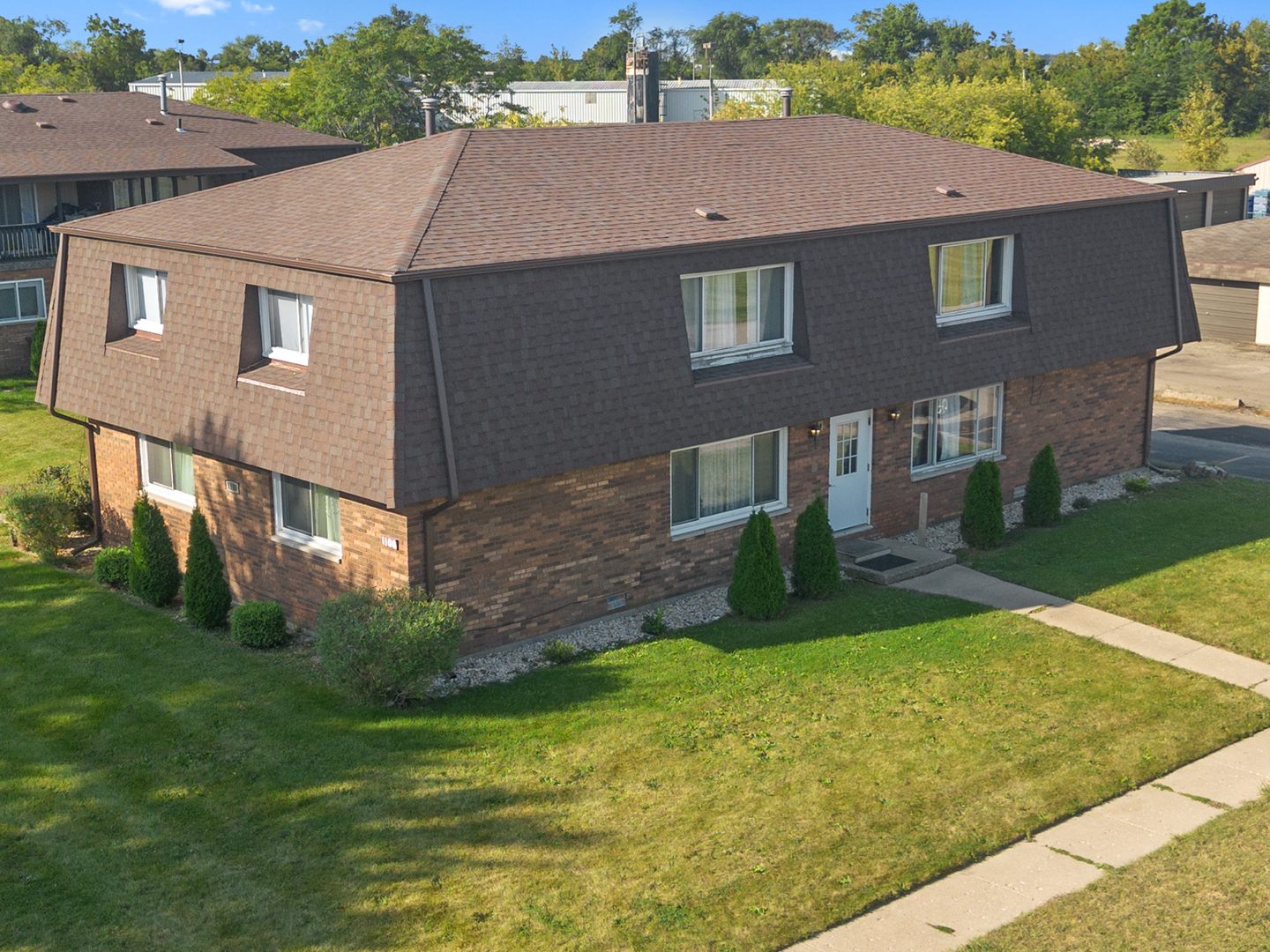 a view of a brick house next to a yard