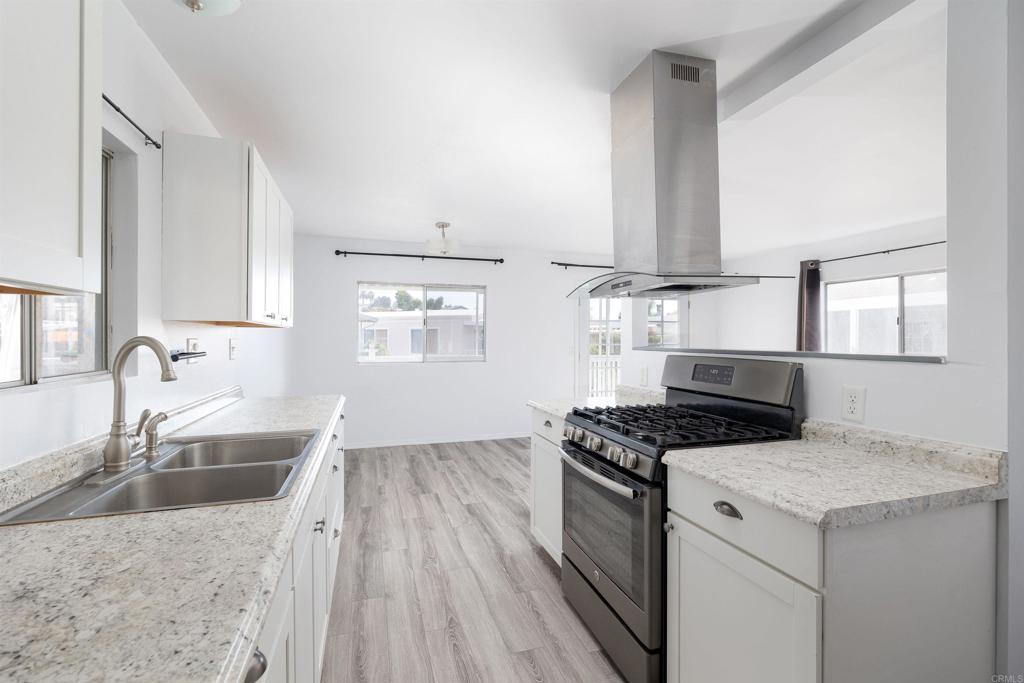 a kitchen with granite countertop a sink stainless steel appliances and cabinets