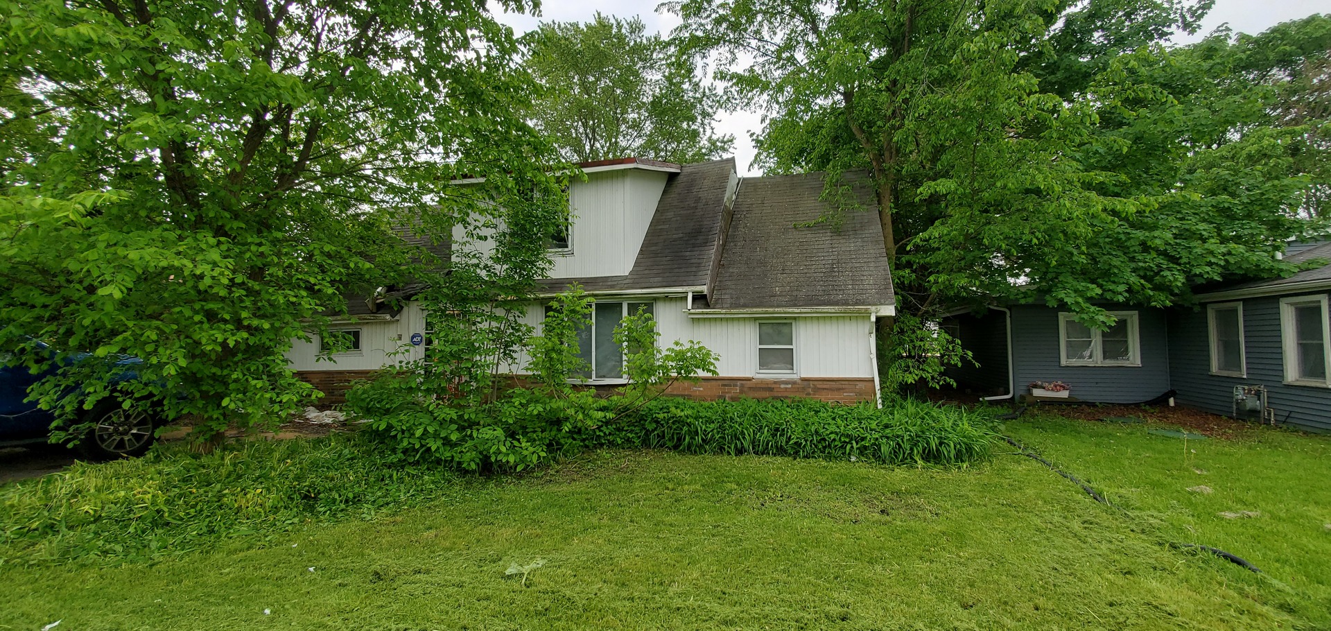 a front view of a house with a yard and trees