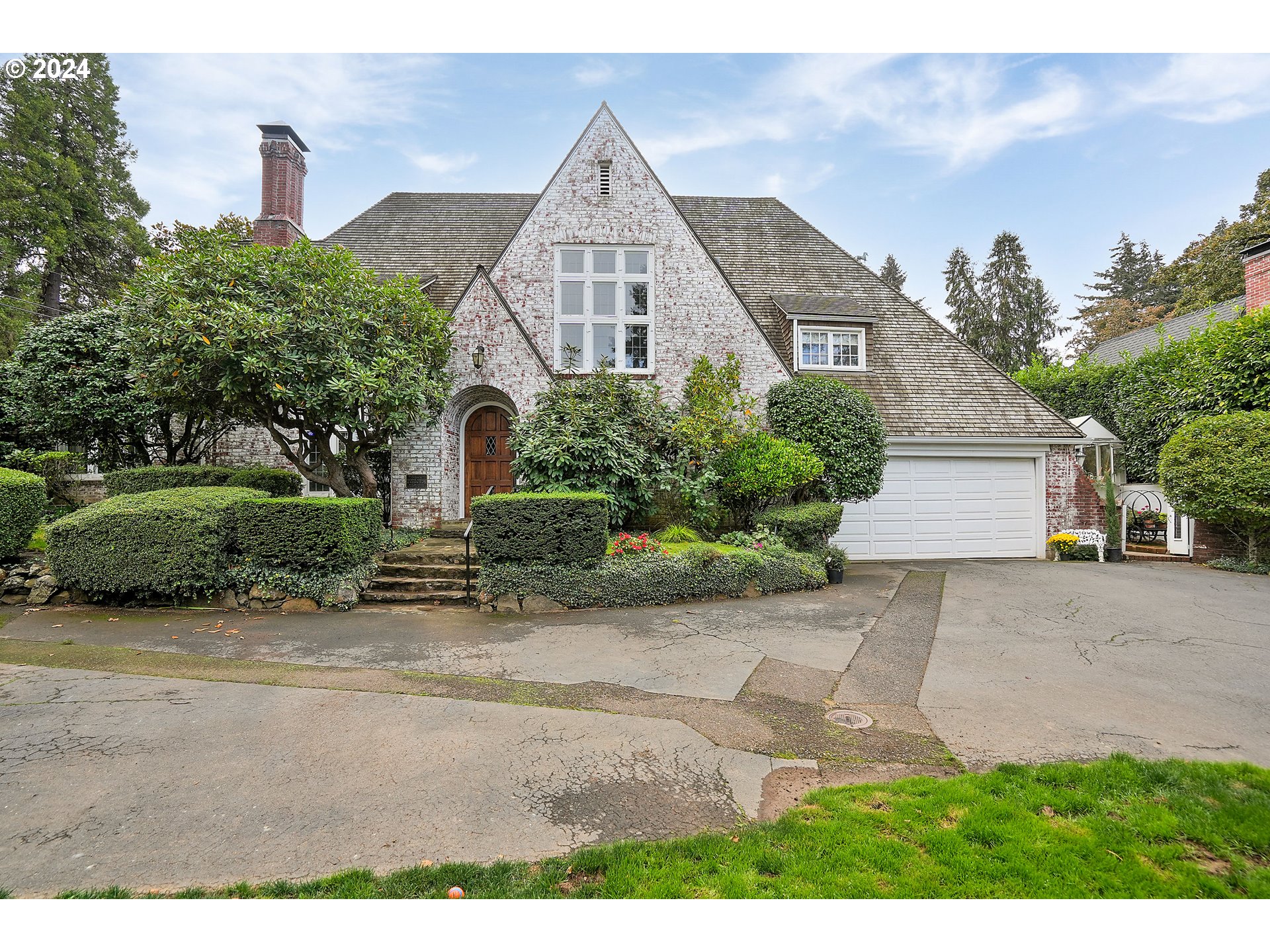 a front view of a house with a garden and plants