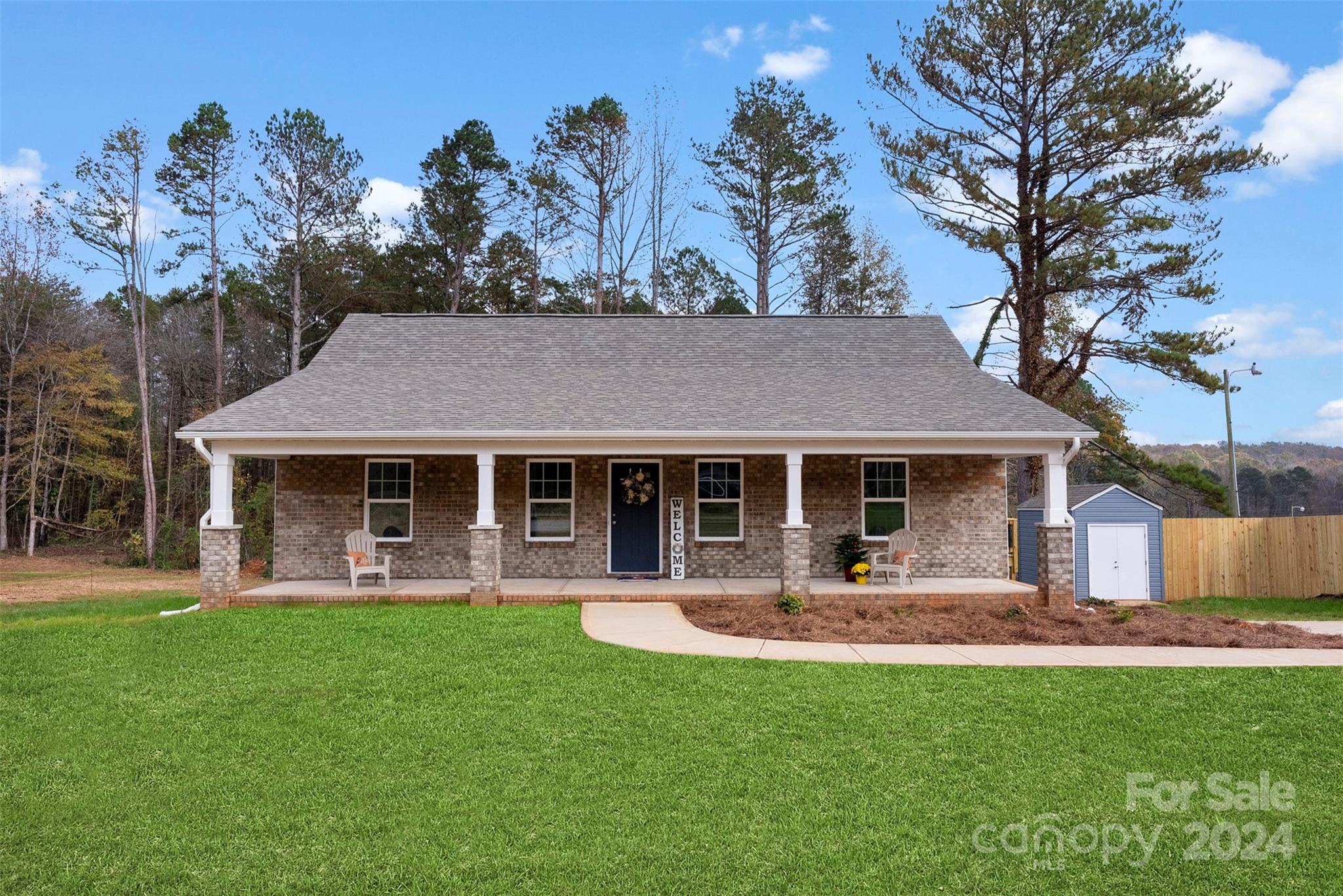 a front view of a house with a yard and trees