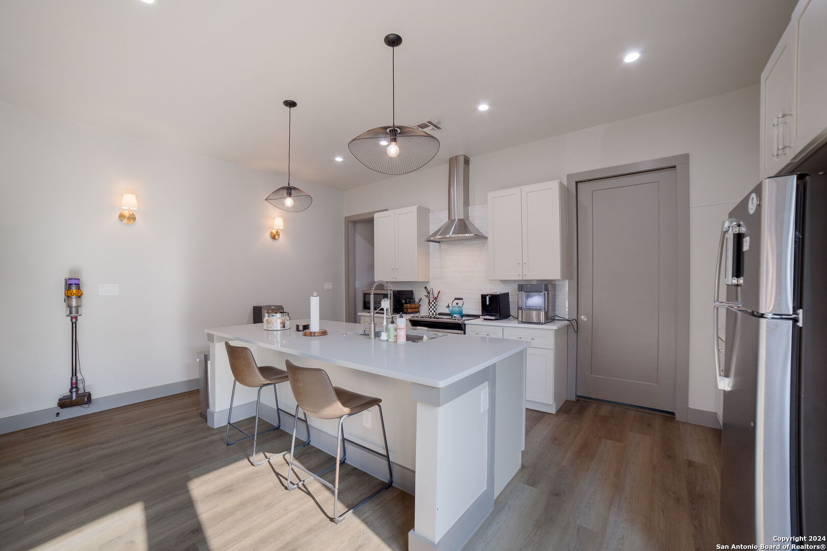 a kitchen with a sink a counter space and wooden floor