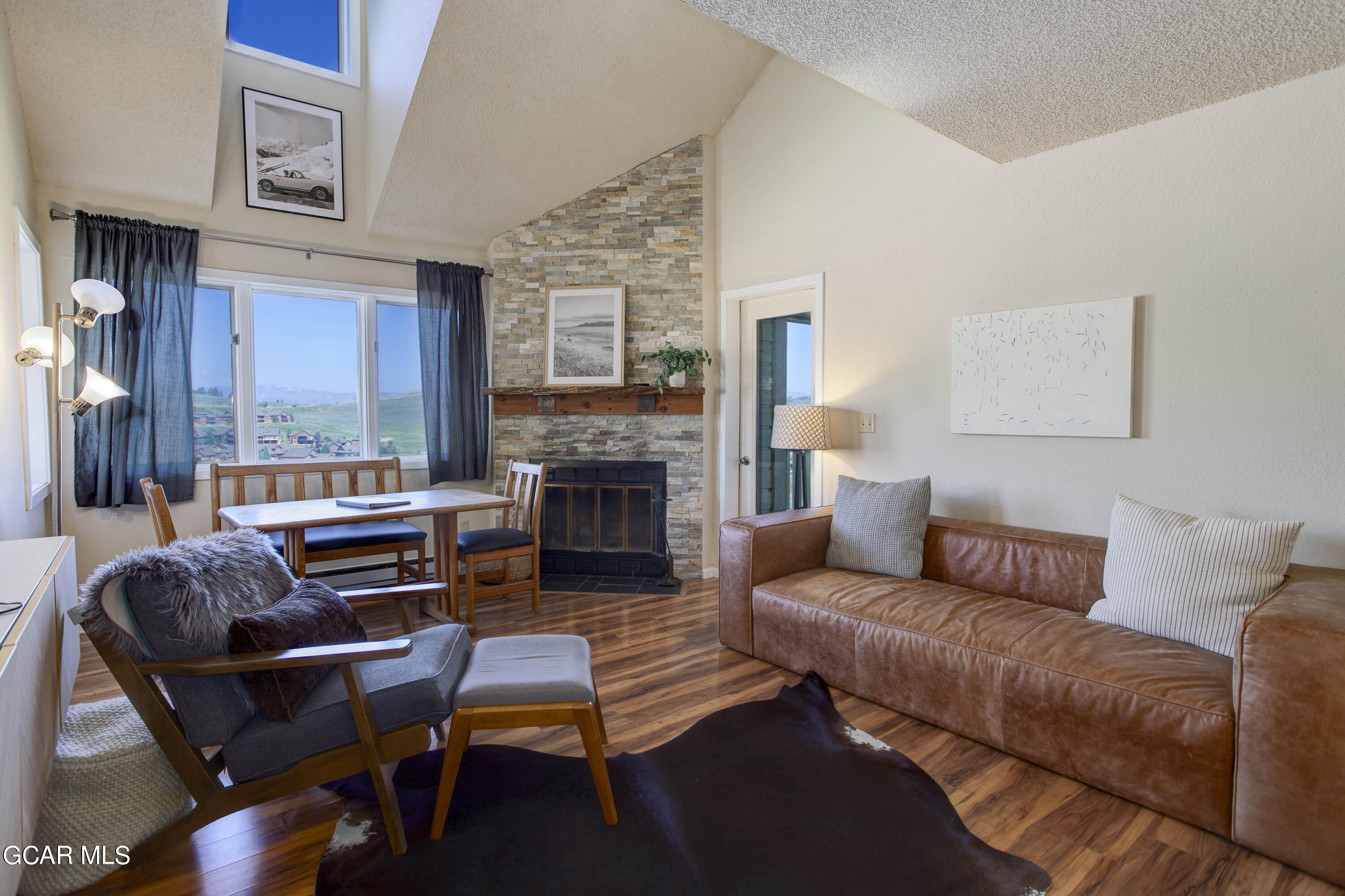 a living room with furniture a fireplace and a large window