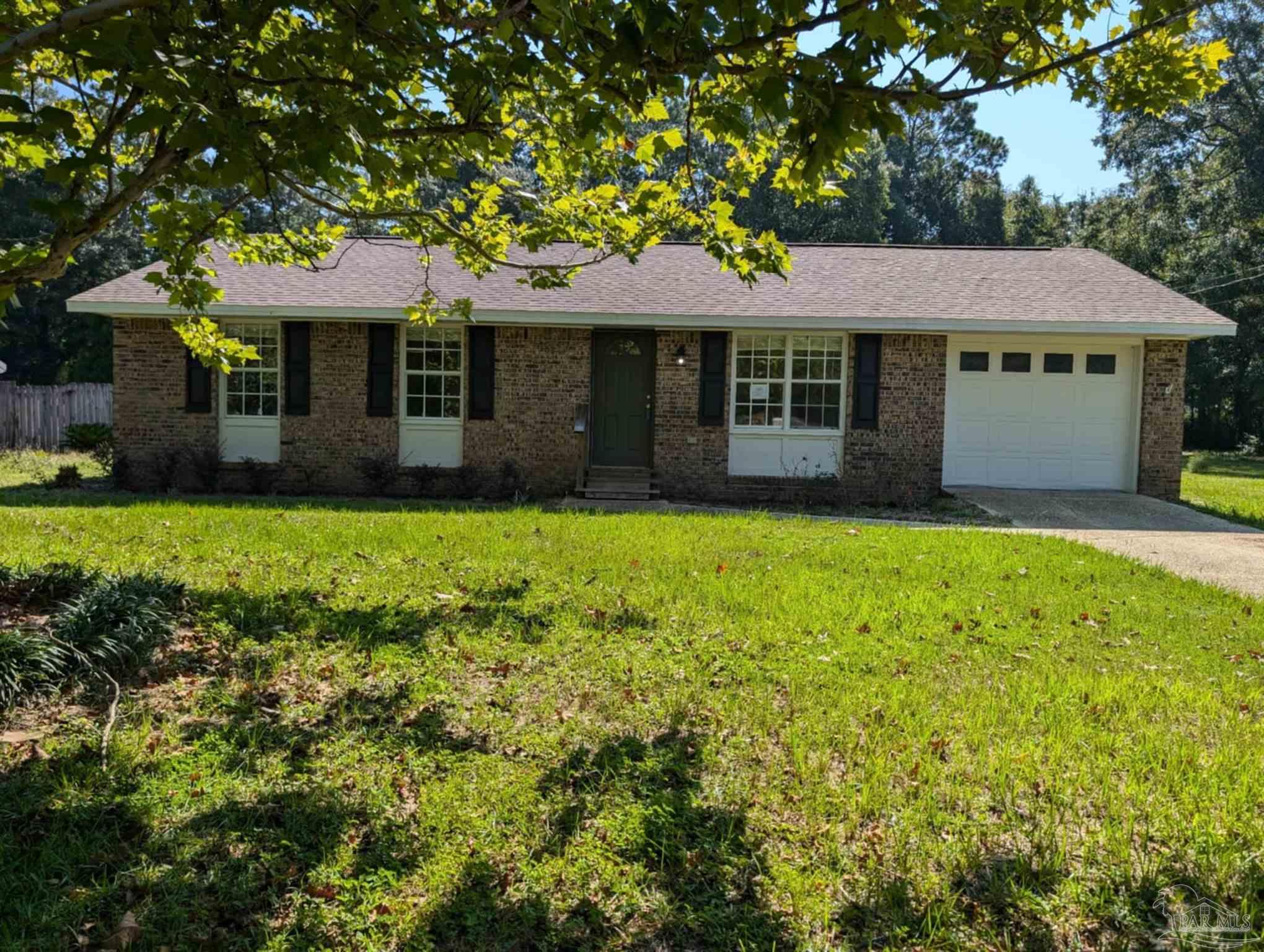 a front view of a house with a yard and trees