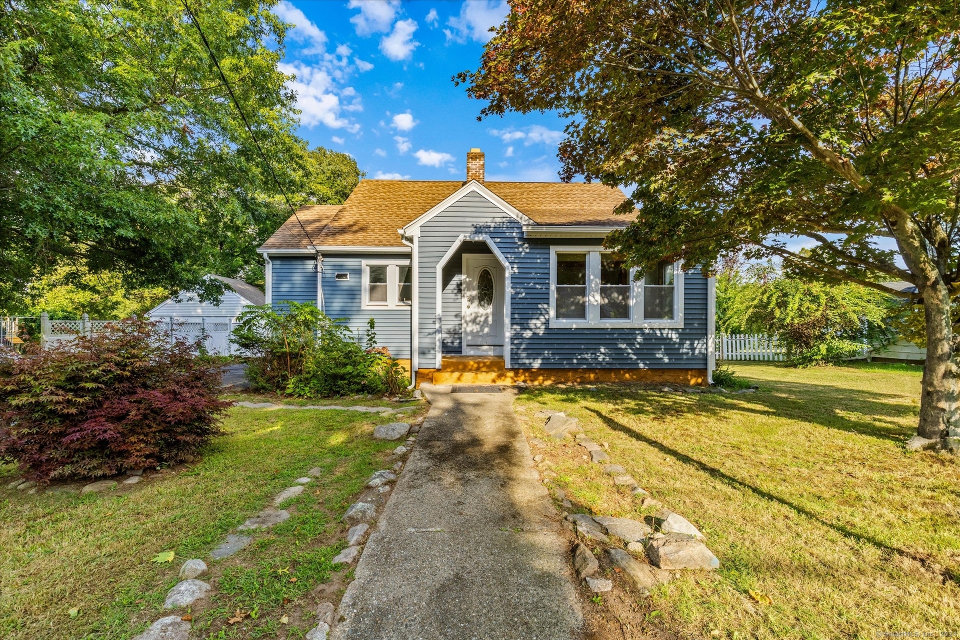 a front view of a house with yard and green space